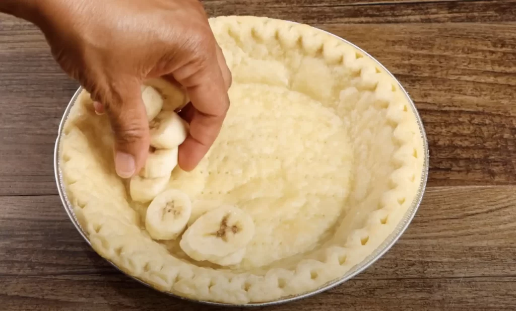 adding the banana to pie crust 